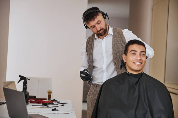 Stylish man in classic suit making hair styling in room indoors - Photo, Image