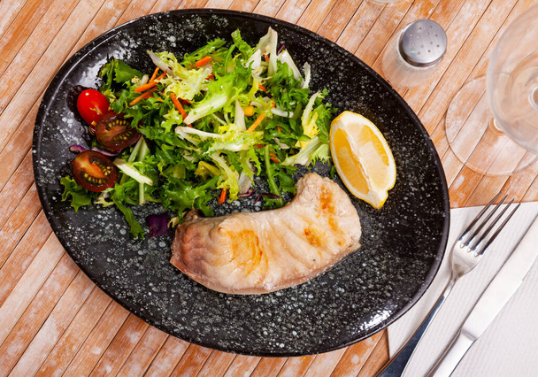Fried porbeagle steak with vegetable salad and lemon wedge - Photo, image