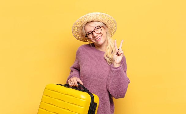 blonde woman smiling and looking friendly, showing number two or second with hand forward, counting down - 写真・画像