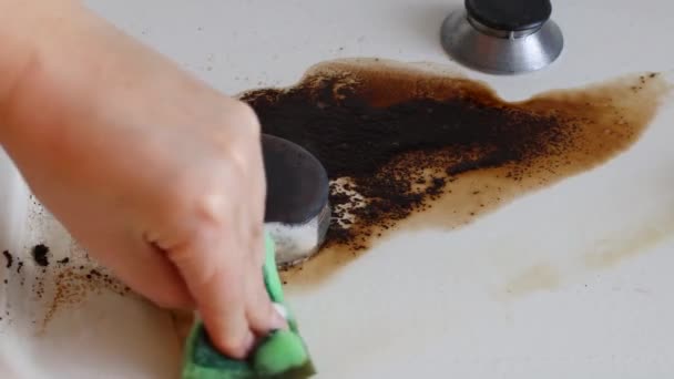 Huishoudelijke vrouwelijke hand reinigen vuile kachel na het koken met behulp van spons voor het wassen. Pech bij het maken van koffie. - Video