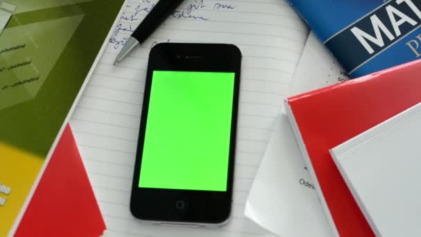 Smartphone (pantalla verde) con libros de trabajo, papel y pluma
 - Imágenes, Vídeo