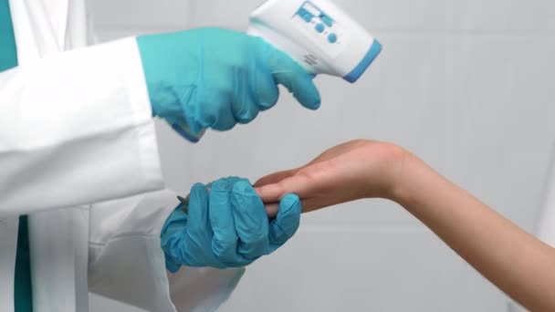 Nahaufnahme eines Arztes, der die Körpertemperatur am Handgelenk einer Patientin misst, Zeitlupe - Filmmaterial, Video