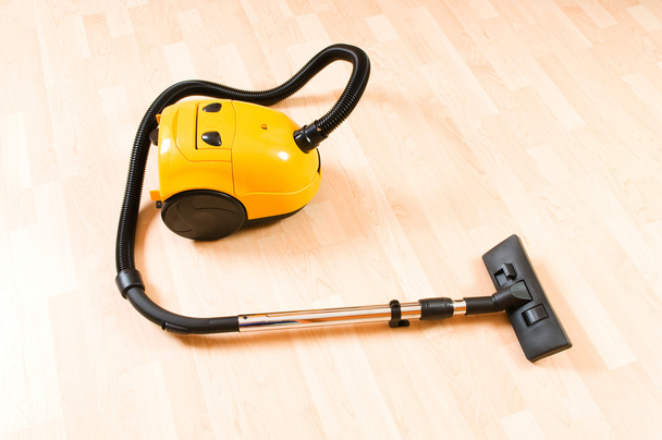 Vacuum cleaner on the polished wooden floor - Fotoğraf, Görsel