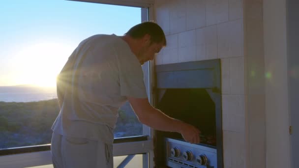 Un hombre en aislamiento durante la cuarentena fríe filetes en casa. - Metraje, vídeo