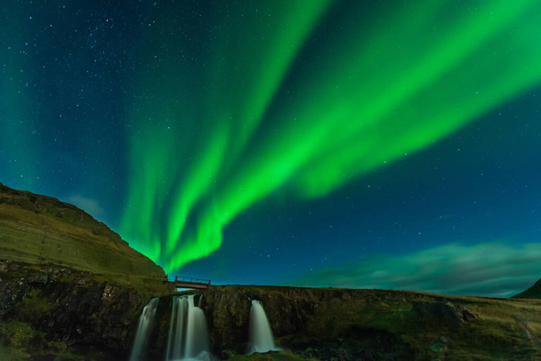 Βόρεια φώτα στην Ισλανδία. Τοπίο γεμάτο kp5 Aurora Borealis. Καταπληκτικό νυχτερινό τοπίο στο Kirkjufell, γραφικό ταξιδιωτικό προορισμό. Πράσινος ουρανός γεμάτος αστέρια. - Φωτογραφία, εικόνα