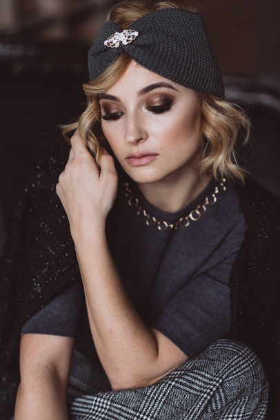 Portrait of a beautiful stylish blonde woman with smoky eye makeup in a knitted headband. Soft selective focus, defocus. No retouching. - Photo, Image