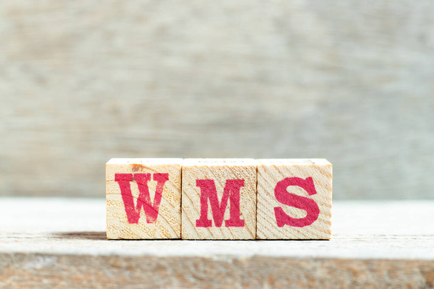 Blok alfabetu literowego w słowie WMS (skrót od systemu zarządzania magazynem) na tle drewna - Zdjęcie, obraz