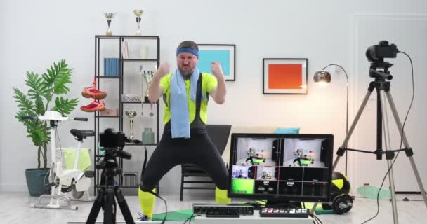 Evdeki vlog için komik görünüşlü fitness eğitmeni egzersiz videoları çekiyor. Spor koçu veya sporcu etkileyicisi canlı yayın rekoru - Video, Çekim