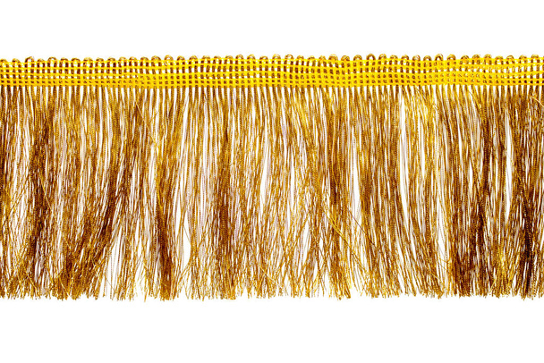The fringe is golden with a long thin pile. Isolated on white background. Decor, design, decoration, texture. - Photo, Image
