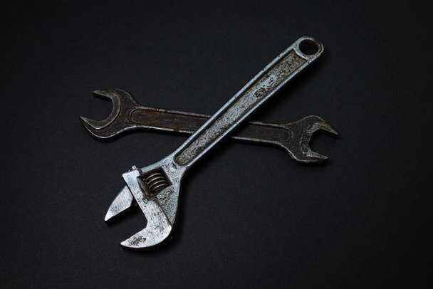 Klíč a nastavitelný klíč na černém pozadí. Staré pracovní nástroje. Ocelové nástroje - Fotografie, Obrázek