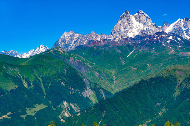 Georgia.Näkymä Kaukasuksen vuorille ja laaksoihin.Taustalla on kaksipäinen vuori Ushba.Blue taivas pieni valkoinen pilvi. - Valokuva, kuva