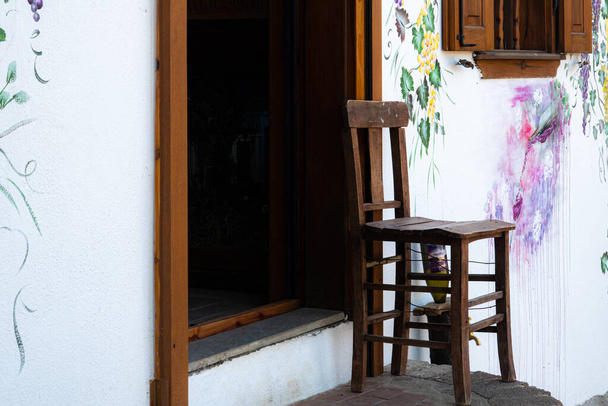 Ancienne entrée de maison individuelle et vieille chaise en bois devant le mur peint - Photo, image