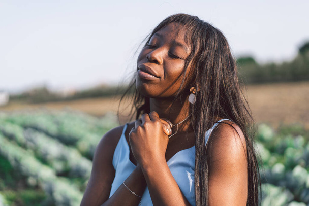 Afro Girl zavřela oči a modlila se venku. Ruce složené v modlitební koncepci pro víru, spiritualitu a náboženství. Africká etnika - Fotografie, Obrázek