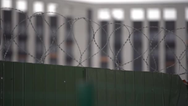 Vysoké vězeňské zdi s ostnatým drátem, vzdálené dráty a strážní věž je patrná na dálku - Záběry, video