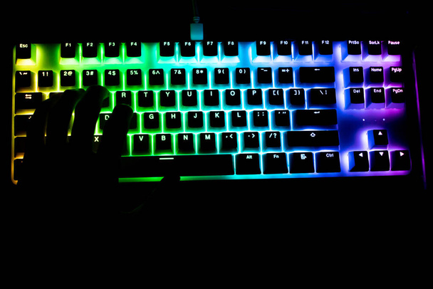 handsilhouet op verlicht toetsenbord - Foto, afbeelding