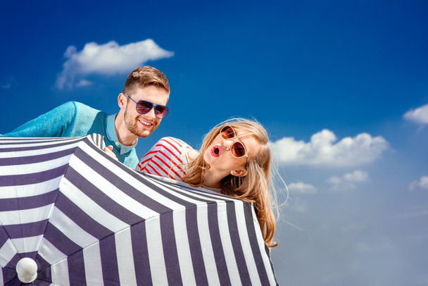 Emocional pareja escondida detrás del paraguas y divertirse en th
 - Foto, Imagen