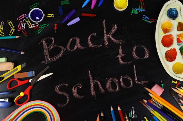 красочный карандаш, краски, кисти и канцелярские принадлежности лежат на доске, возвращаясь к школьной концепции - Фото, изображение