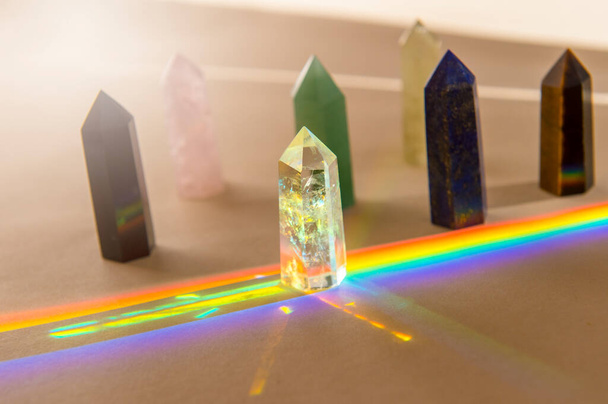 Healing chakra crystals and rainbow on beige background. Meditation, reiki and spiritual healing concept - Photo, Image