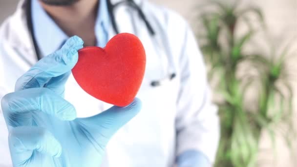  arts hand in hand latex handschoenen houden rood hart close-up  - Video