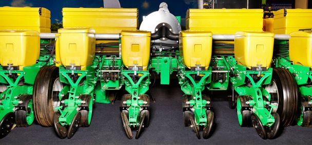 Zöld sárga bunkerekkel, modern többsoros növényekkel, kerekekkel, elosztócsövekkel és pneumatikus mezőgazdasági vetőgép munkagépekkel. - Fotó, kép