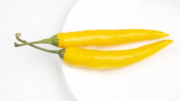 Sárga csípős chili egy tányéron. Paprika. Növényi vitaminok. - Fotó, kép