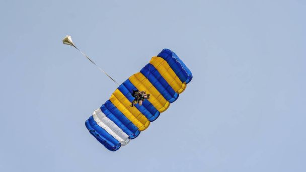Paraquedistas em tandem contra um céu azul claro com paraquedas abertos prontos para pousar - Foto, Imagem