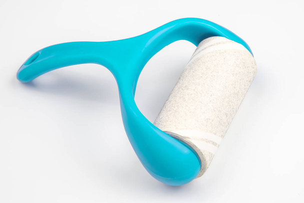 sticky plastic roller for cleaning clothes from dust, lint and hair on a white backgroun - Photo, Image
