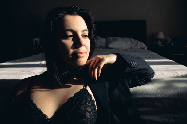 сексуальные портреты молодой женщины в куртке и бюстгальтере резкий свет - Фото, изображение