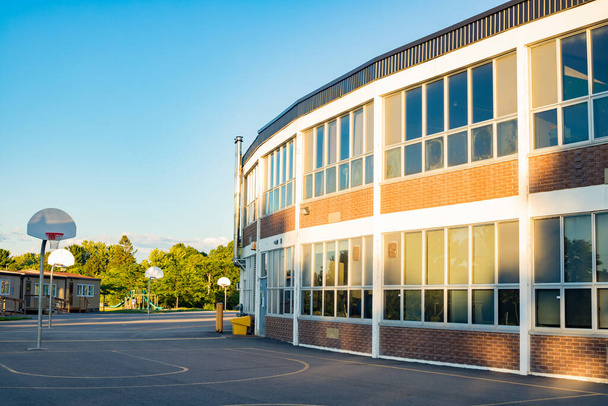 Bâtiment scolaire et cour d'école avec terrain de basket - Photo, image