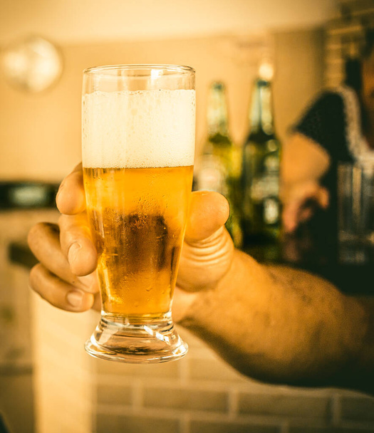 close up of hand holding beer on a pub blurred background - Fotografie, Obrázek