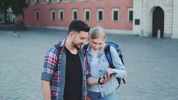 Ευτυχισμένοι τουρίστες με smartphone εύρεση όμορφο μέρος στο κέντρο της παλιάς ευρωπαϊκής πόλης - Φωτογραφία, εικόνα