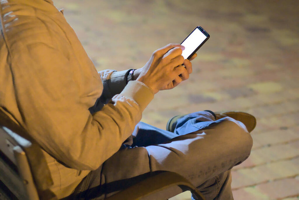 Oříznutý pohled na mužské ruce držící chytrý telefon s prázdnou obrazovkou pro kopírování textové zprávy nebo informačního obsahu v urbanistickém nastavení - Fotografie, Obrázek