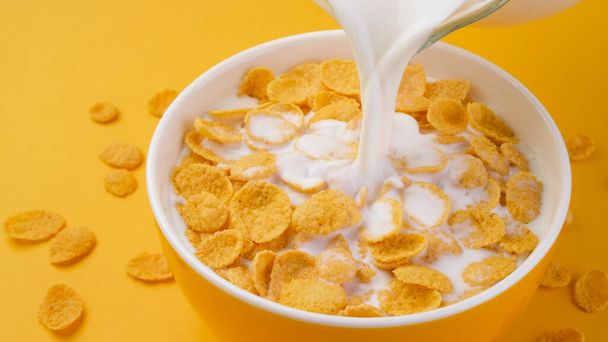 Latte versato in ciotola di corn flakes - Foto, immagini