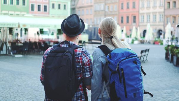 Blick auf ein Touristenpaar mit Taschen, das die Karte auf dem zentralen Stadtplatz checkt - Foto, Bild