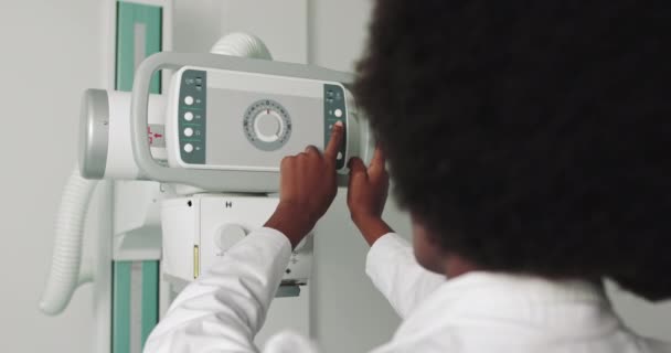 Retrato de Médico Profissional Etnia Africana Sorrindo à Câmera. No Hospital, a Técnica Feminina ajusta a Máquina de Raio-X. Hospital moderno com equipamentos médicos tecnologicamente avançados - Filmagem, Vídeo