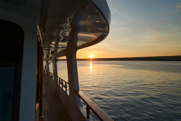 beautiful and spectacular sunset over a motor yacht with reflections on the white paint and details of the vessel, lying in the great darwin bay of genovesa island, galapagos islands, Ecuador - Photo, Image