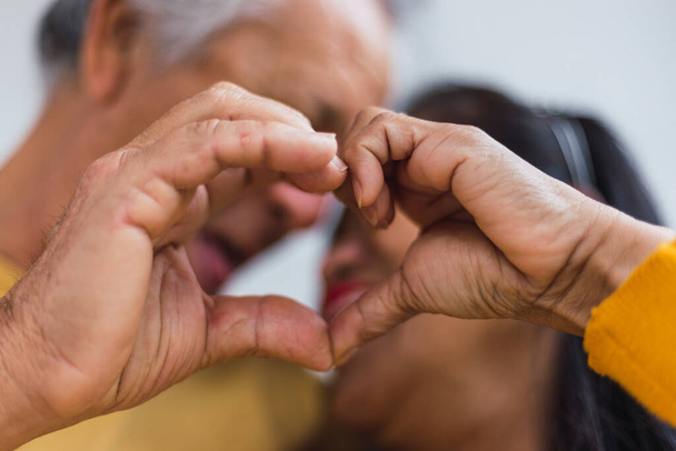 Primer plano de una pareja de ancianos irreconocibles haciendo un corazón - Foto, imagen