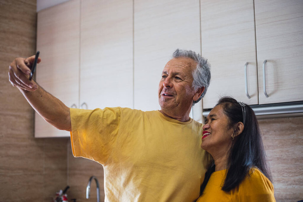 Spiel gelbes Paar mittleren Alters macht ein Selfie - Foto, Bild