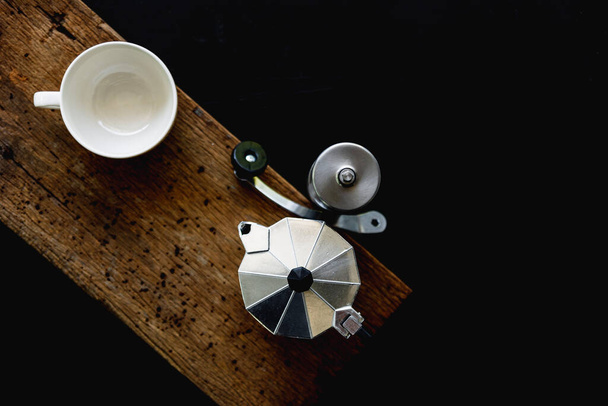 Moka pot and white cup on dark background. Coffee making concept. - Photo, Image