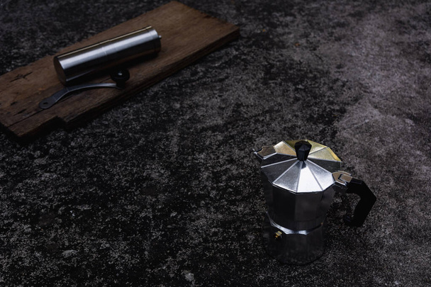.Moka pot et moulin à café sur fond sombre. Concept de fabrication du café. - Photo, image