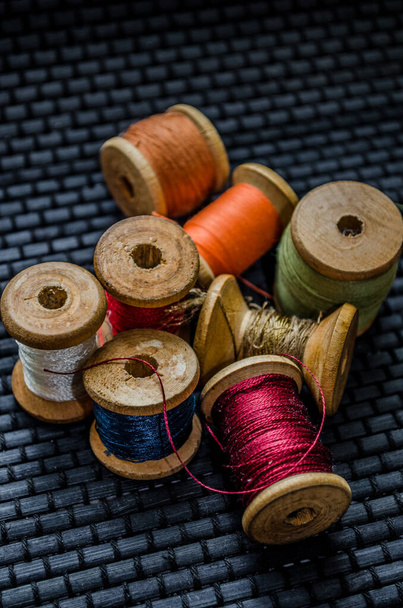 Retro naaiwerk: schaar op maat, snijmes, vingerhoed, houten draadspoelen, kussen voor het opnemen van spelden, stoffen en naaiaccessoires. - Foto, afbeelding