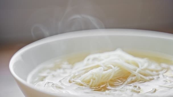 Горячая традиционная китайская рисовая лапша в миске. - Кадры, видео