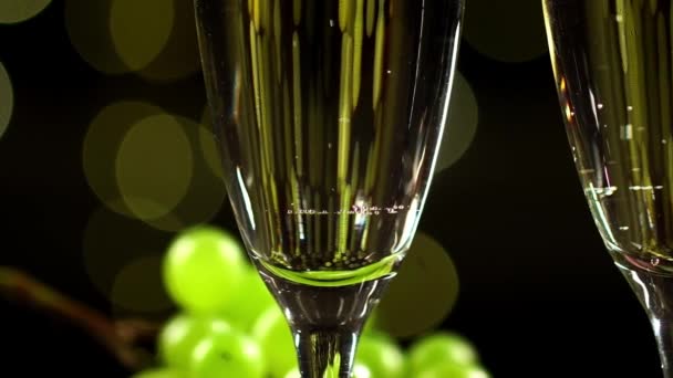 Макро-вид двух бокалов с игристым вином на фоне освещения - Кадры, видео