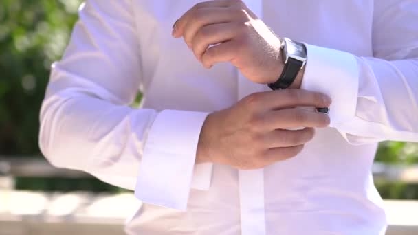 Muž si nasadí hodinky, zatímco se připravuje na svatební obřad - Záběry, video