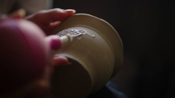 Artisanat féminin décoré pot d'argile en poterie. Femme inconnue dessin sur pot - Photo, image