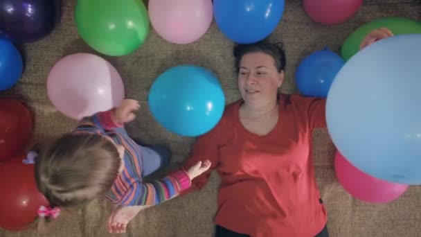 Η γιαγιά παίζει με την εγγονή της σε πολύχρωμες, φουσκωτές μπάλες - Πλάνα, βίντεο