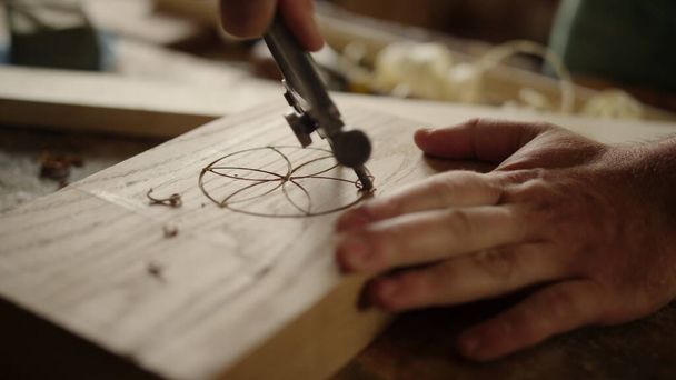 Muž vyrábějící vzor na dřevěných výrobcích uvnitř. Tesař používající nástroj k řezbářství - Fotografie, Obrázek
