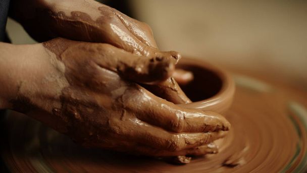 Mujer manos esculpir producto de arcilla en el taller. Lady modeling pot en estudio - Foto, Imagen