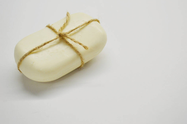 White soap tied with a rope lies on a white background. - Photo, Image