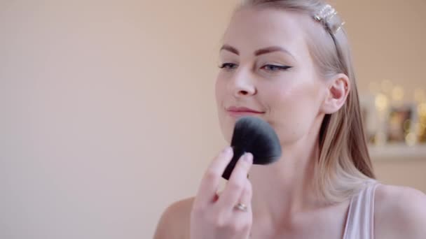Atractiva hembra haciendo maquillaje aplicando polvo - Imágenes, Vídeo
